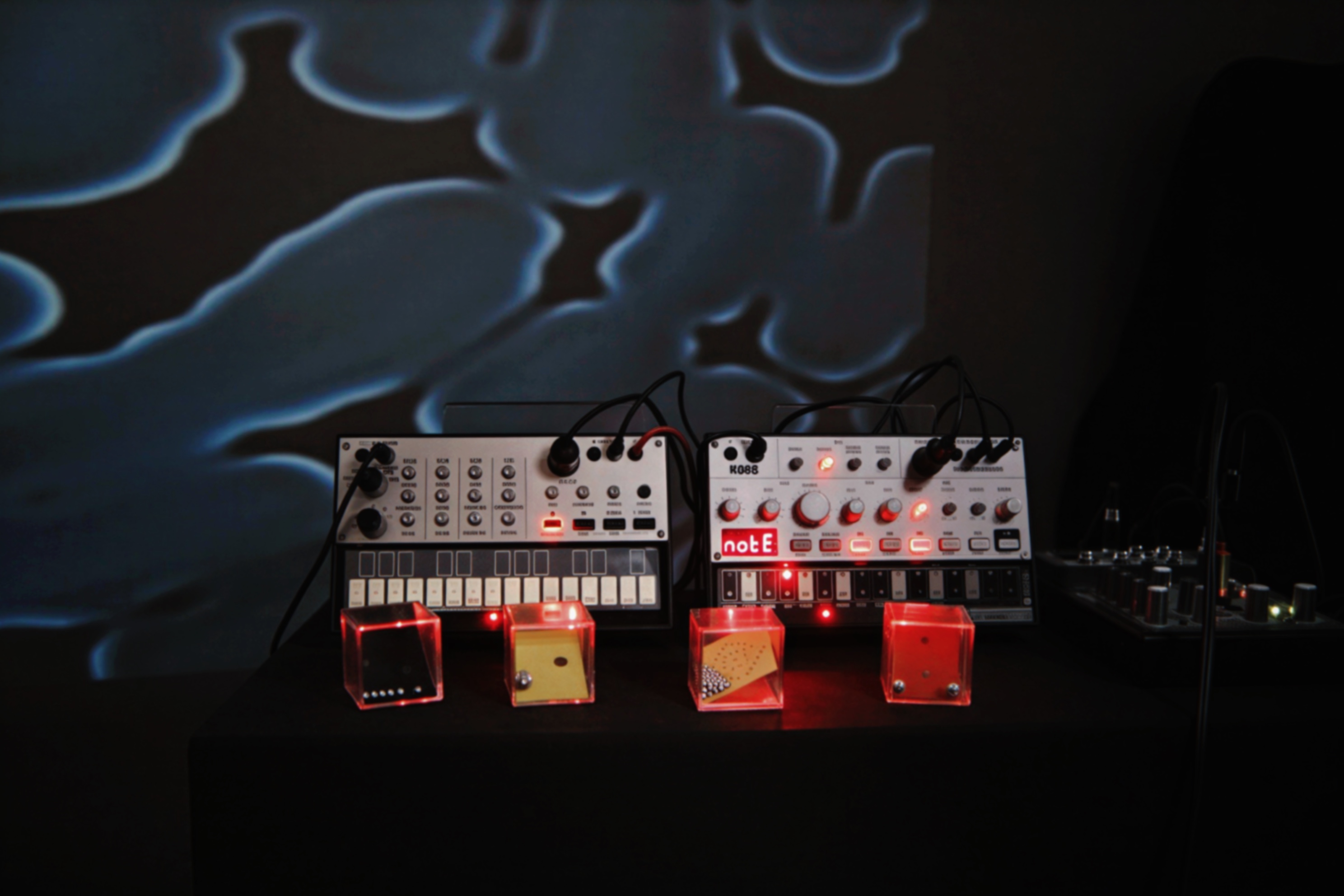 Ausstellungsraum mit Liegestühlen, Projektion und Synthesizer-Setup